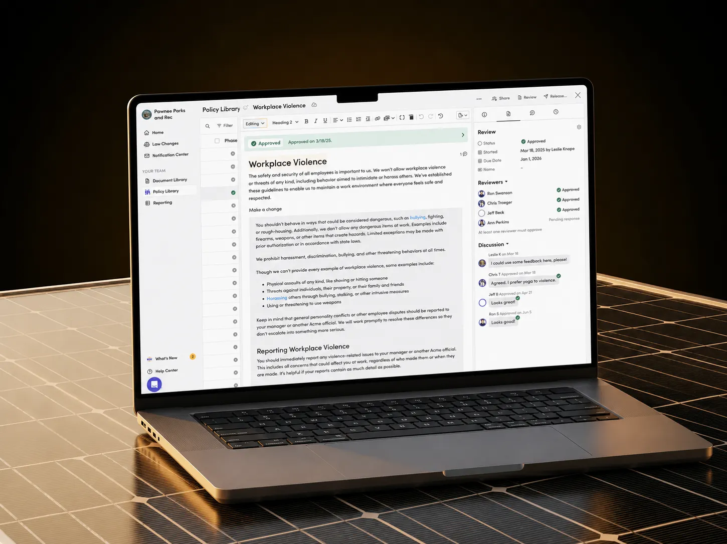 Blissbook on a laptop: a workplace-violence policy open in the editor, with its approval status, reviewers and discussion thread alongside