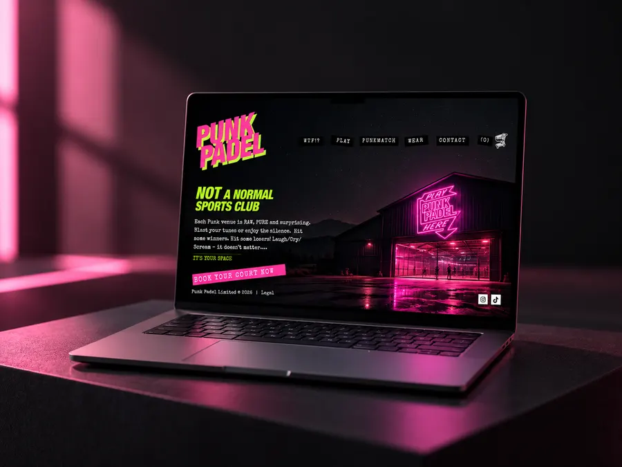 The PunkPadel homepage on a laptop: neon pink and green lettering over a floodlit barn venue